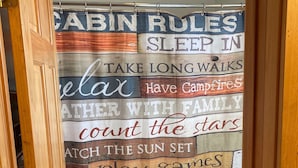 A bathroom with a shower curtain featuring cabin rules. - Wolf Pack place of Pomme de Terre Lake! (Pittsburg)