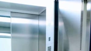 A metallic elevator interior with a control panel and emergency phone. - Modern executive level suite in Metepec (Metepec)