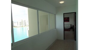 A corridor with a large window offering a view of a body of water and buildings. - Modern executive level suite in Metepec (Metepec)