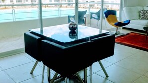 A modern living room with a glass table, a blue and yellow chair, and a white sofa. - Modern executive level suite in Metepec (Metepec)