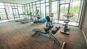 Ett gym med löpband, styrketräningsmaskiner och träningsbollar.