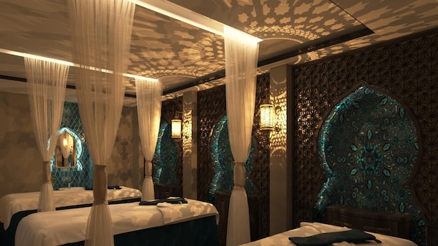 A room with two beds, each with a canopy, and ornate wall decorations. - Babylon Premium Hotel & Spa (Hanoi)