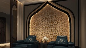 A modern lounge with a geometric patterned wall, leather seating, and a decorative lamp. - Babylon Premium Hotel & Spa (Hanoi)