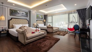 A modern hotel room with a large bed, a sofa, a desk, and a chair. There is a large window with curtains, a hanging chair, and a flat-screen TV. - Babylon Premium Hotel & Spa (Hanoi)