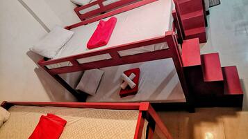 Una habitación tipo dormitorio con literas y una cama individual.