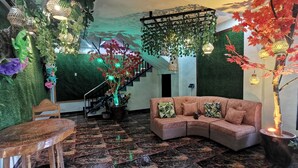Ein modernes Wohnzimmer mit einer gebogenen Couch, einem Holzstuhl und einer Treppe mit grüner Wand.
