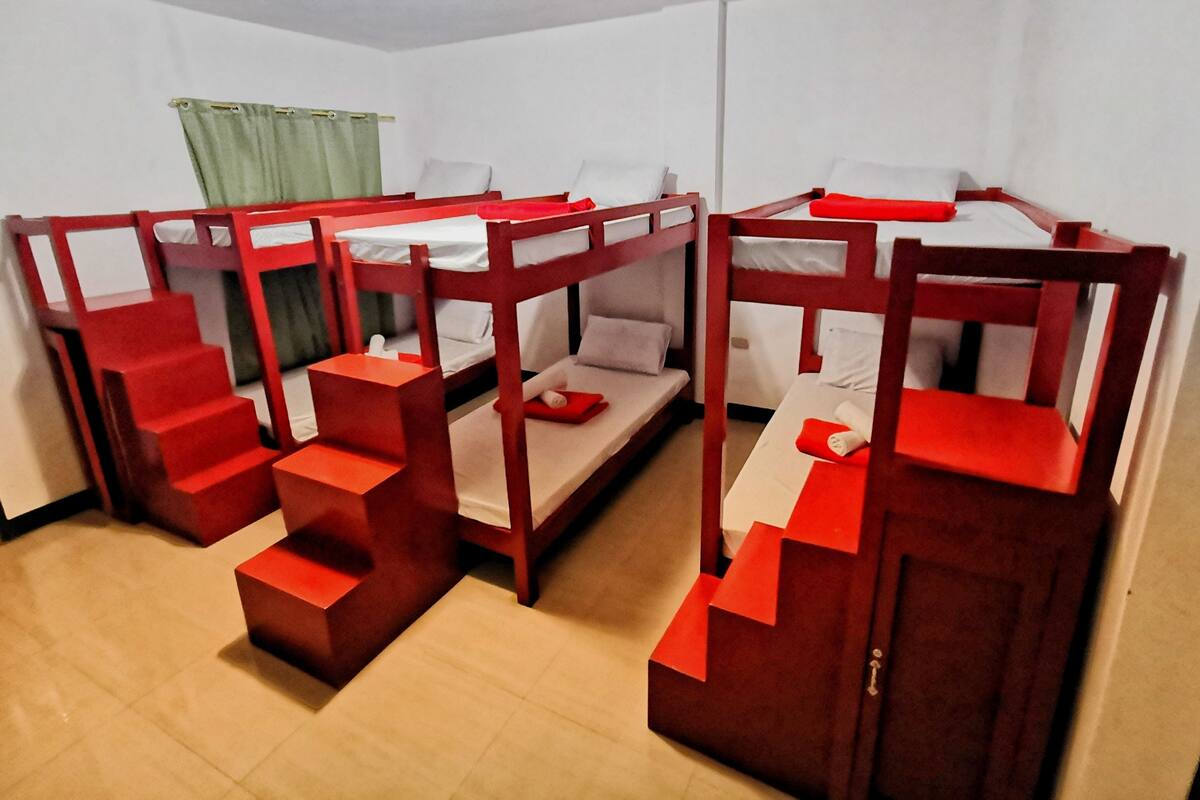 A room with bunk beds, each with a small table and a pillow. There are steps leading to the beds.