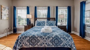A bedroom with a large bed, two bedside tables, a ceiling fan, and a window with curtains. - Spacious (2/1, 1100 sqf) - 5 -15 minutes to Airport, Downtown, SeaWorld, etc. (San Antonio)