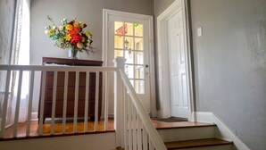 A staircase with a white railing, a wooden handrail, and a door with frosted glass panels. - Spacious (2/1, 1100 sqf) - 5 -15 minutes to Airport, Downtown, SeaWorld, etc. (San Antonio)