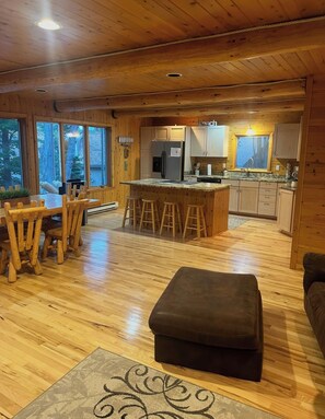 A wooden interior with a dining area, kitchen, and seating space.