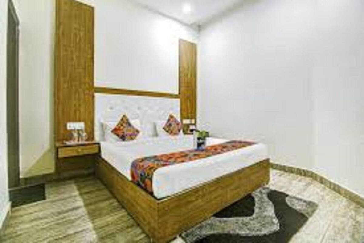 A bedroom with a wooden bed frame, a bedside table, and a nightstand.