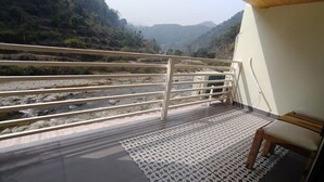 Un balcón con vista a un río y colinas.