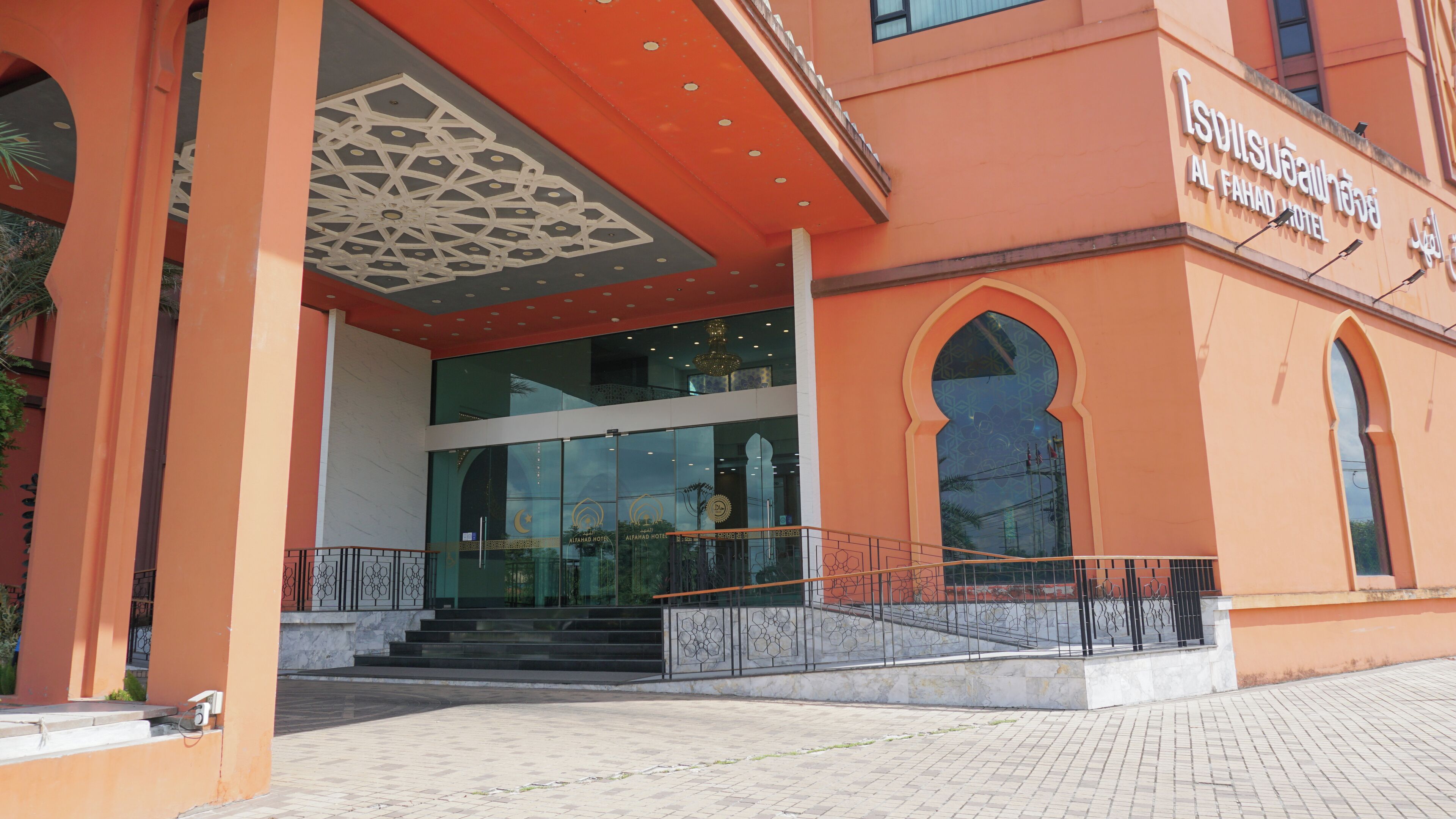The exterior of Al Fahad Hotel with a modern design, featuring a prominent entrance with glass doors and a decorative ceiling.