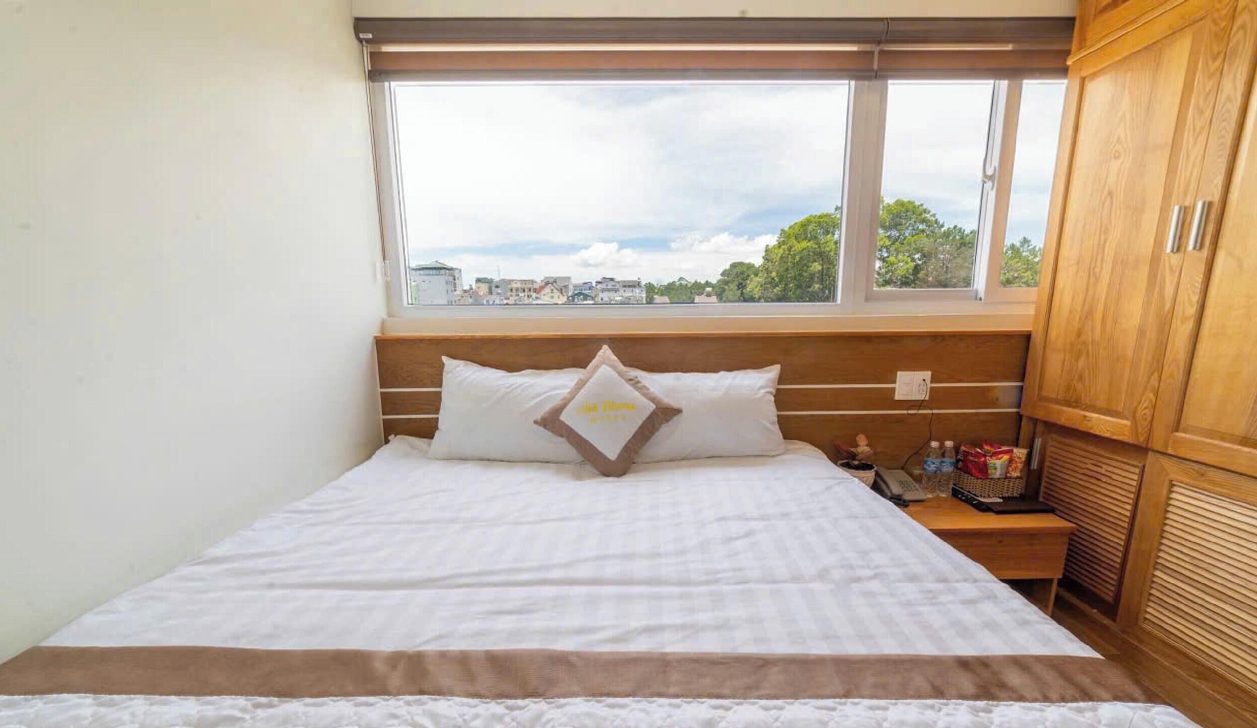 A bedroom with a bed, a window, and wooden furniture.