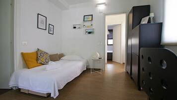 Une chambre à coucher avec un lit, une petite table et une armoire.