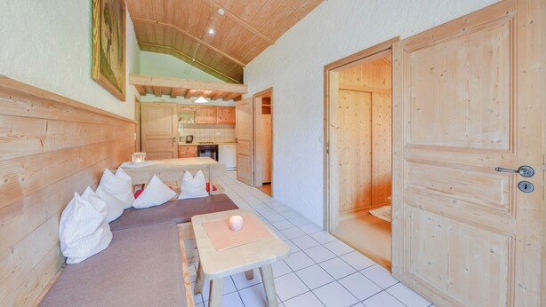 Un interior de madera con comedor, cocina y una puerta.
