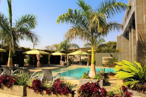 Kolam renang outdoor, dengan payung kolam renang dan kursi berjemur