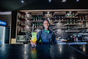 Una zona de bar con estantes llenos de botellas y un microondas.