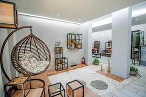 Un interior moderno con una silla colgante, una mesa de madera y una estantería.