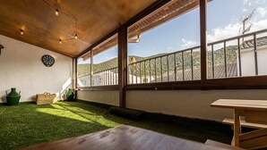 Una habitación con techo de madera, un dardo, un cubo verde y una mesa de picnic.