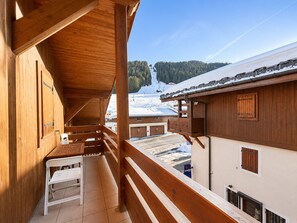 Ein Holzbalkon mit Blick auf eine verschneite Berglandschaft.