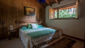 A wooden room with a bed, a window, and a painting on the wall. - Perfect for honeymoon C10 (Lázaro Cárdenas)