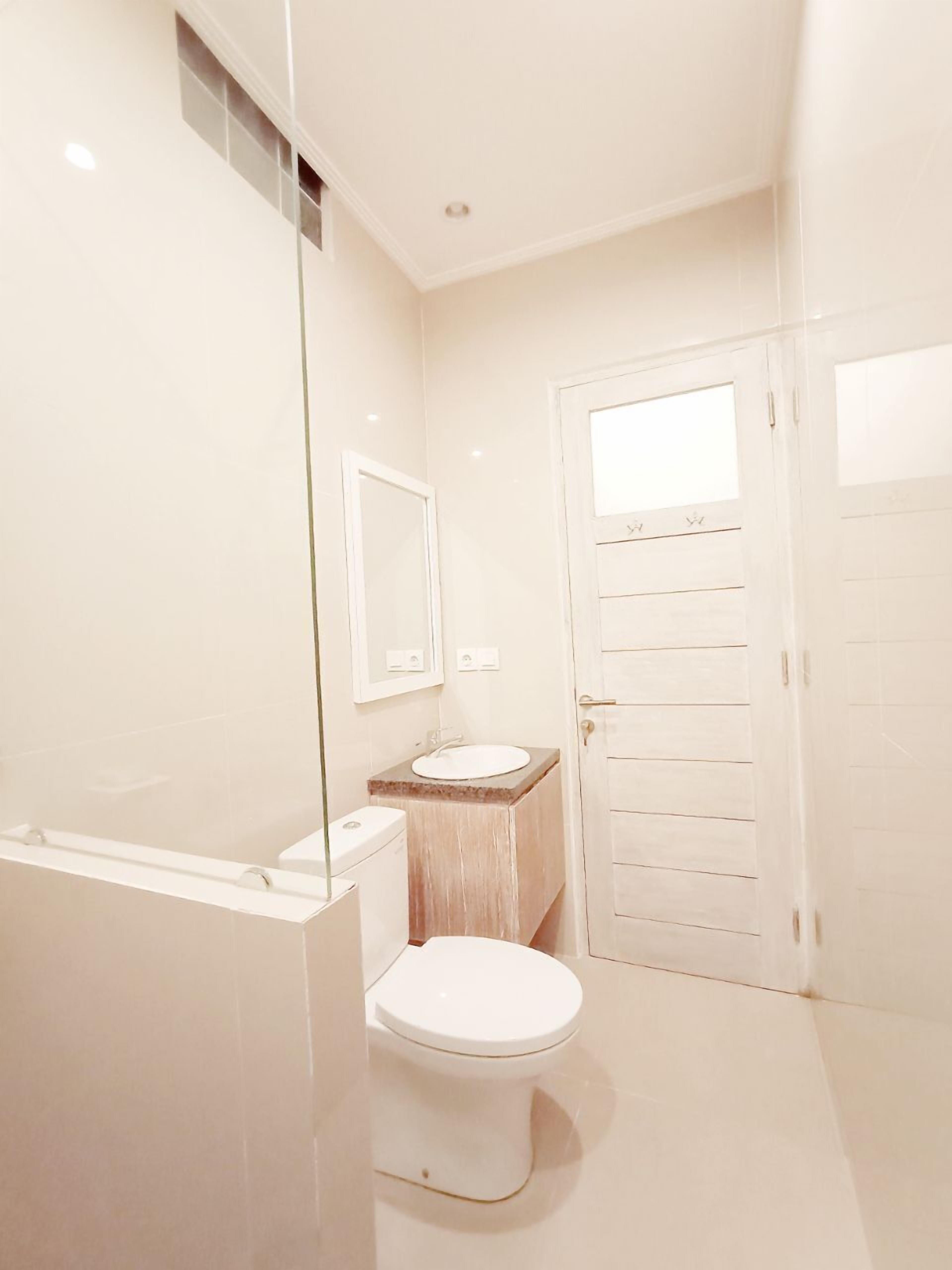 Un baño con inodoro, lavabo y espejo.