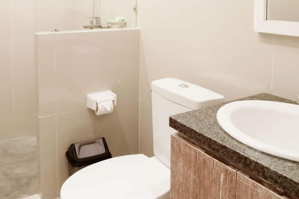 Un baño moderno con inodoro, lavamanos y ducha.
