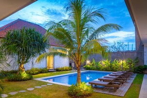 Una piscina al aire libre, sillones reclinables de piscina