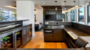 A modern kitchen with a built-in oven, a large island, and a bar area. - NEW!!Denvers ONLY centralTrain HUB "union station", downtown upscale living! (Denver)
