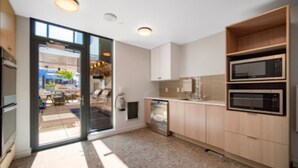 A modern kitchen with built-in appliances, a glass door entrance, and a view of the outside. - NEW!!Denvers ONLY centralTrain HUB "union station", downtown upscale living! (Denver)