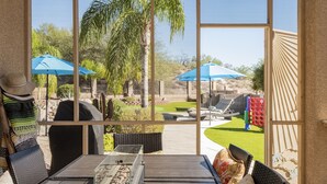 A patio with outdoor furniture, a grill, and blue umbrellas. - Relaxing Vacation with Catalina Views & EV Charging 21315404 (Tucson)