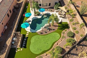 Uma área de piscina no terraço, com uma piscina pequena, espreguiçadeiras e guarda-sóis.