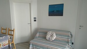 A room with a bed, a table, and a door. - Chez Bonjour: holiday home with large terrace overlooking the mountains (Villar Pellice (TO))