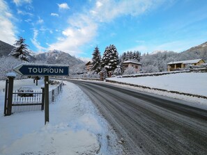 Sneklædt vej med et skilt, der viser 'TOUPIUN', og huse i baggrunden.