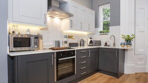 A modern kitchen with a built-in oven, microwave, and toaster. - Bootham Luxury Apartments Flat 2 (York)