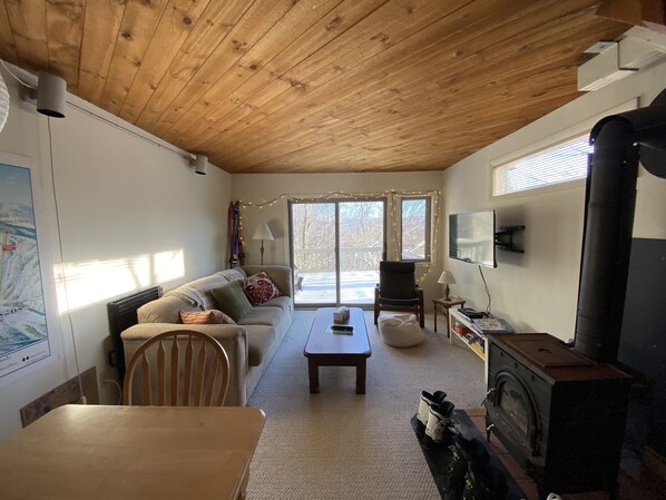 Relax in this inviting living room with a sofa, dining table, and fireplace.