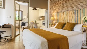 A hotel room with a large bed, a desk, and a kitchenette. - Misterhost Patio de las Flores Triana I (Sevilla)