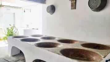 Una cocina con una isla central amplia, que cuenta con varios fogones y un lavamanos.