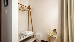 A minimalist room with a wooden bunk bed, a small table with a vase, and a waste basket. - ❤️Lima AIRPORT❤️ 4 min AWAY I 3 BDR I Smartlocks (Callao)