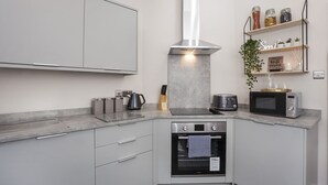 A modern kitchen with a built-in oven, a microwave, a toaster, and a kettle on the countertop. - Sleeps 6 guests  in 2 bedrooms (York)
