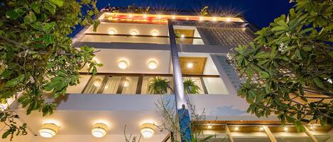 A multi-story hotel with illuminated windows and a modern architectural design.