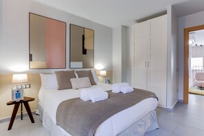 A hotel room with a bed, bedside tables, a wardrobe, and a bathroom visible through an open door. - Sweett | Callao I - Three Bedroom Apartment, Sleeps 7 (Barcelona)
