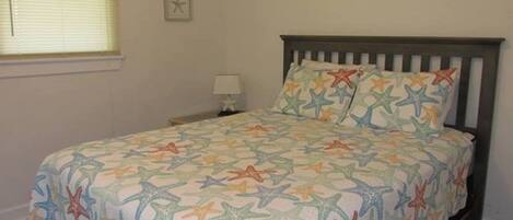 Una camera da letto con un letto, un comodino, una lampada e una sveglia a muro.