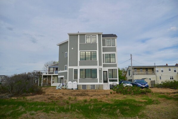 A multi-story residential building with a modern design, featuring large windows and a flat roof. - Modern house at Wells Beach - Available Winter Rentals Off Season-reduce rate. (Wells)