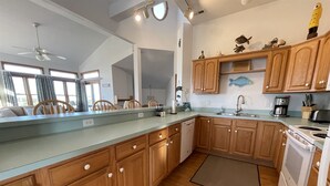 A modern kitchen with wooden cabinets, a dishwasher, and a stove. - The Baited Hook a great vacation destination for the family! (Frisco)
