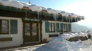 Ein Gebäude mit einem Schild, auf dem "Flur des Hirs" steht. Schnee bedeckt das Dach und den Boden.