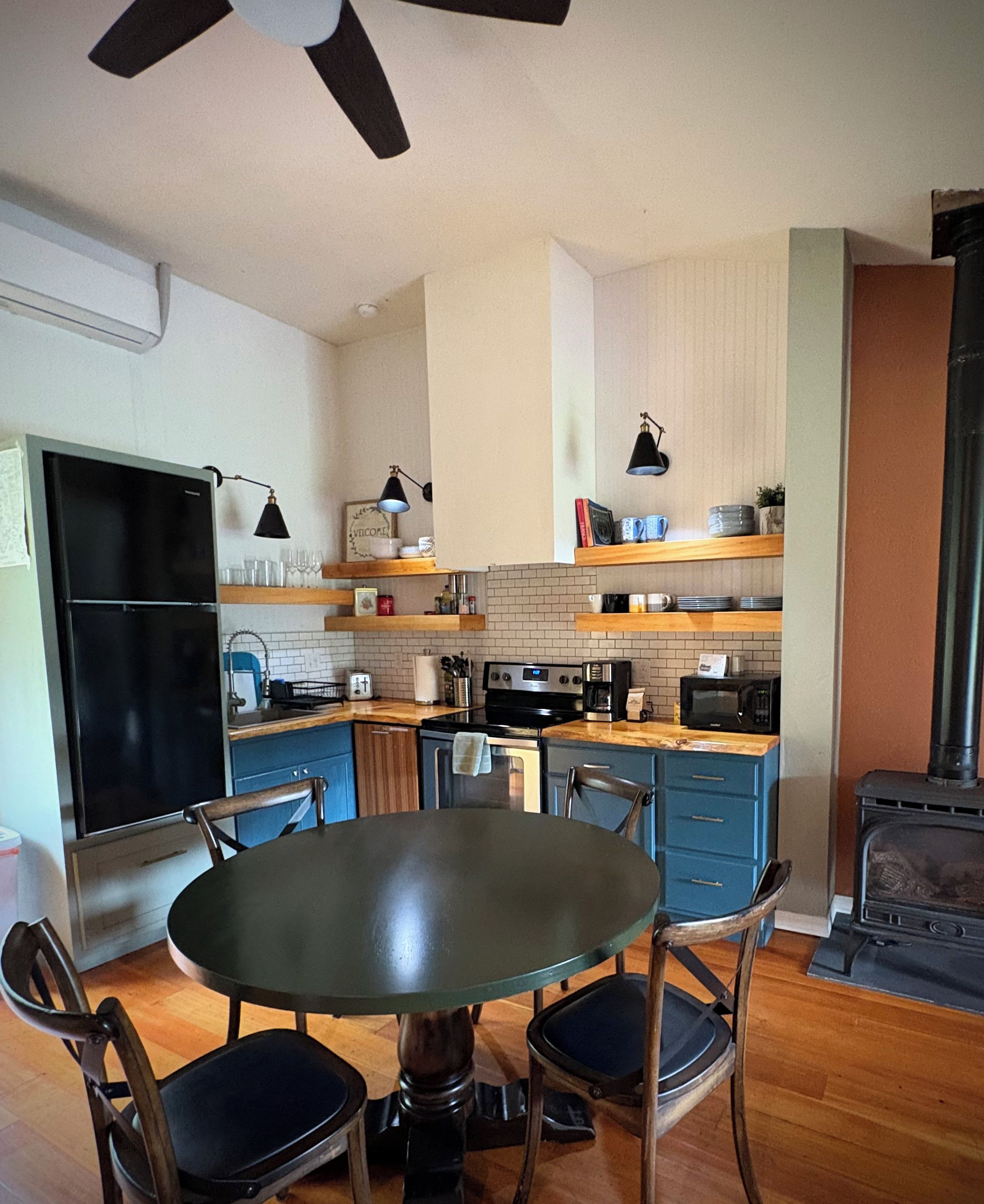 Cozinha moderna com mesa de jantar, cadeiras e fogão embutido.