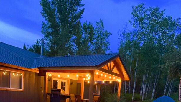 A cabin with a deck, outdoor seating, and string lights. - Upscale lodging duplex minutes from Glacier NP (Coram)