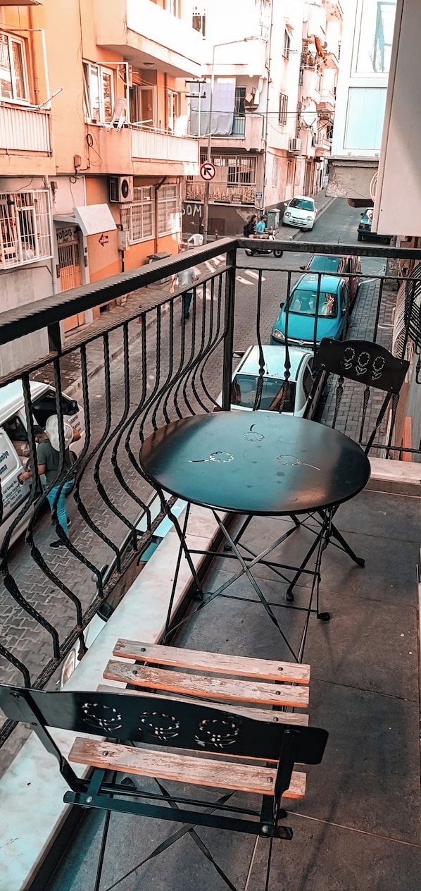 A balcony with a metal railing, a round table, and a wooden bench. - Lord Aydin (Aydin)